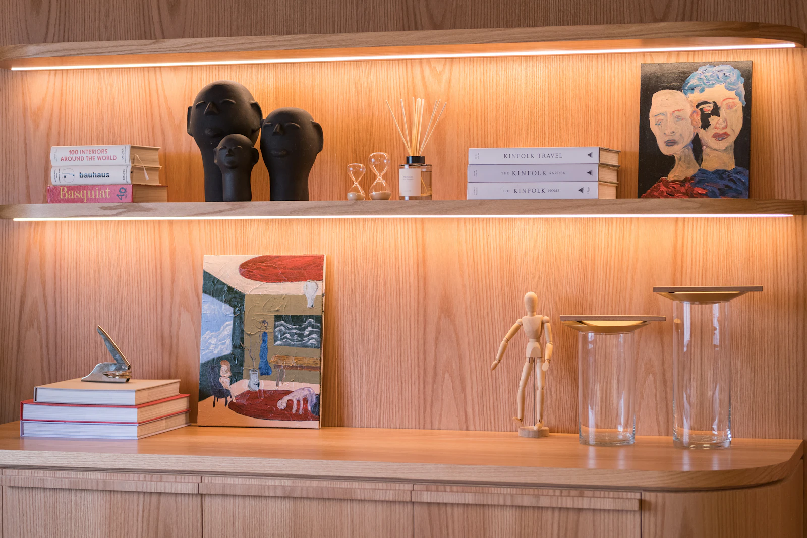 Beleuchtetes Holzregal mit Büchern und Wohnaccessoires – Symbolbild